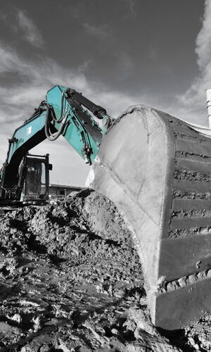 Bagger mit ausgehobener Schaufel auf einer Baustelle vor dem Kieler Stadthaus